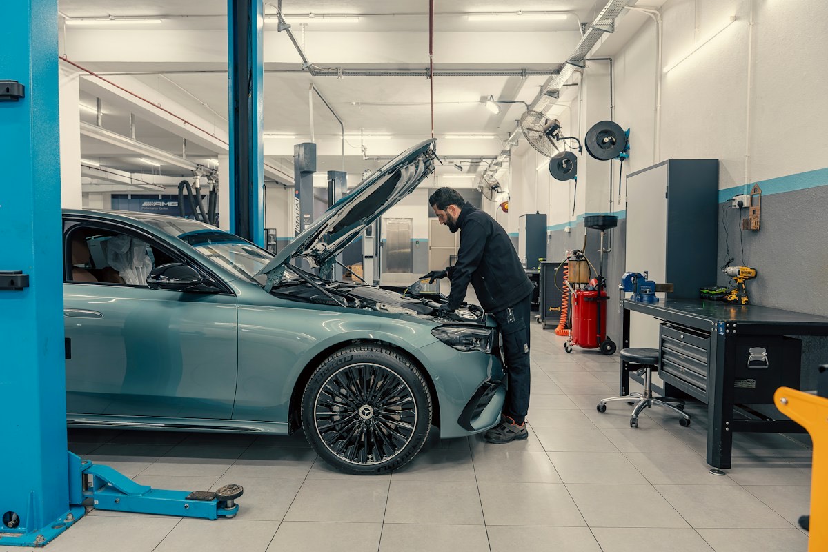 Meccanico al lavoro sul motore di un'auto in officina